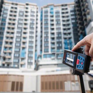 Profissional da construção civil usando o medidor a laser GLM 150-27C para medir prédio